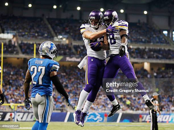 Kyle Rudolph of the Minnesota Vikings celebrates a second quarter touchdown with Adrian Peterson while playing the Detroit Lions at Ford Field on...