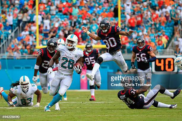 Lamar Miller of the Miami Dolphins runs with the ball for a touchdown in the second quarter against the Houston Texans at Sun Life Stadium on October...