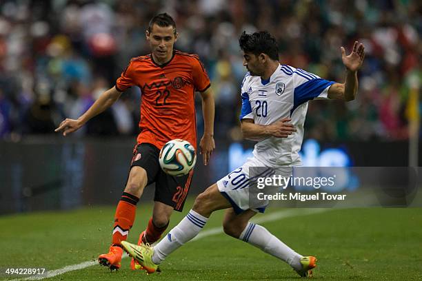 Paul Aguilar of Mexico tries to dribble with Omri Ben of Israel during a FIFA friendly match between Mexico and Israel ahead the beginning of the...