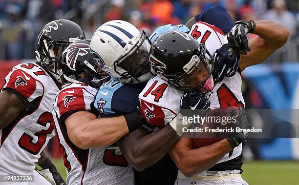Nathan Stupar of the Atlanta Falcons grabs Justin Staples of the Tennessee Titans as he attempts to tackle Eric Weems of the Atlanta Falcons during...