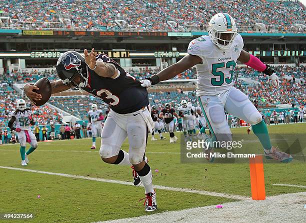 Arian Foster of the Houston Texans scores a touchdown over Jelani Jenkins of the Miami Dolphins during a game at Sun Life Stadium on October 25, 2015...
