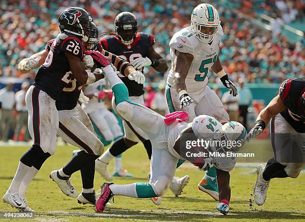 Damien Williams of the Miami Dolphins is tackled by Rahim Moore of the Houston Texans during a game at Sun Life Stadium on October 25, 2015 in Miami...