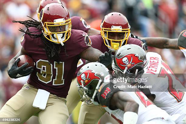 Running back Matt Jones of the Washington Redskins carries the ball while cornerback Alterraun Verner of the Tampa Bay Buccaneers and cornerback Mike...