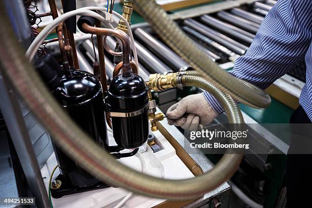 Worker carries out leak testing on a condenser on the assembly line of the Carrier Midea Pvt. Manufacturing facility in Bawal, Haryana, India, on...
