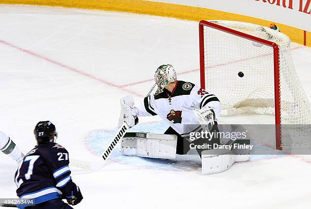 Nikolaj Ehlers of the Winnipeg Jets watches as his shot flies into the net behind goaltender Darcy Kuemper of the Minnesota Wild for a first period...