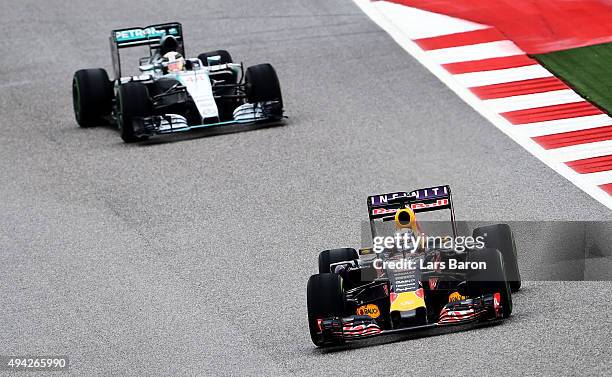 Daniel Ricciardo of Australia and Infiniti Red Bull Racing drives ahead of Lewis Hamilton of Great Britain and Mercedes GP during the United States...