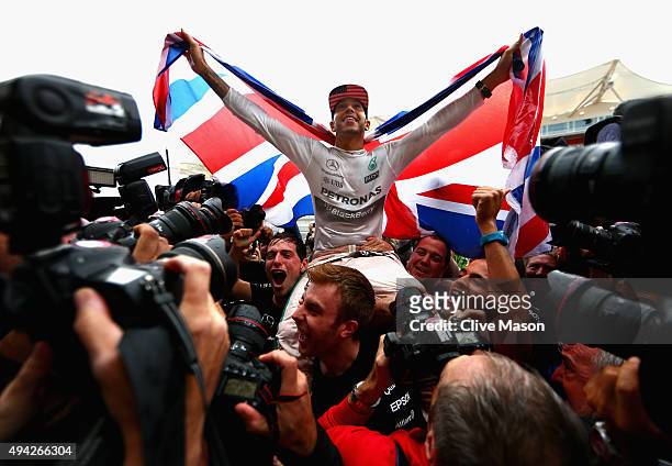 Lewis Hamilton of Great Britain and Mercedes GP celebrates with the team in the pit lane after winning the United States Formula One Grand Prix and...
