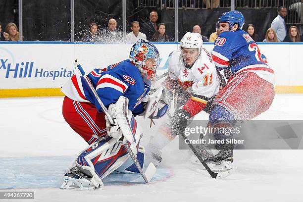 Antti Raanta of the New York Rangers tracks the puck as Ryan McDonagh of the New York Rangers and Mikael Backlund of the Calgary Flames crash the net...