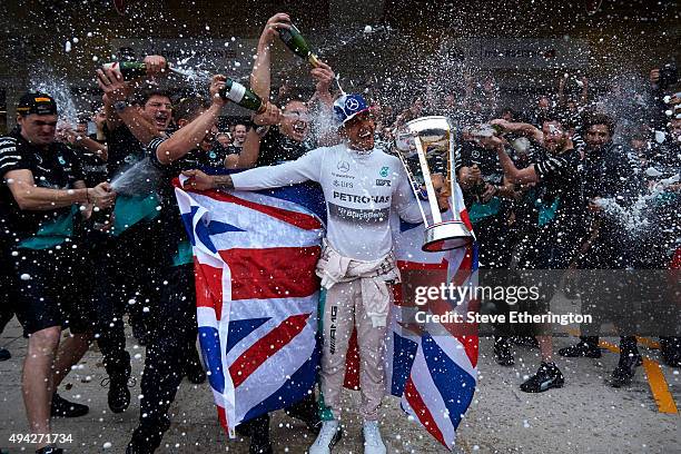 Lewis Hamilton of Great Britain and Mercedes GP celebrates with the team in the pit lane after winning the United States Formula One Grand Prix and...