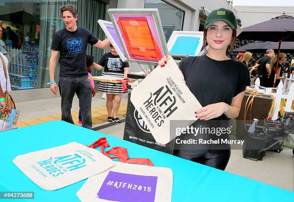 Actress Niki Koss prints tote bags for guests during the Elizabeth