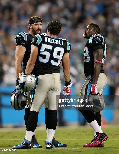 Teammates Jared Allen Luke Kuechly and Thomas Davis of the Carolina Panthers talk during a break against the Philadelphia Eagles at Bank of America...