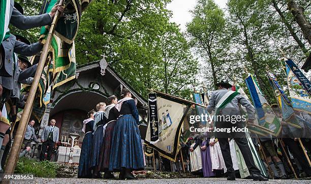 Pilgrims in traditional Bavarian folk costumes and traditional flags gather for an outdoor mass to celebrate Ascension at the open-air altar at...