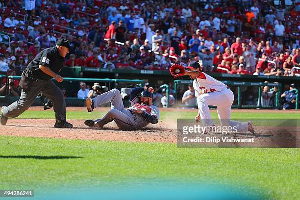 Ryan Doumit of the Atlanta Braves scores a run against Carlos Martinez of the St. Louis Cardinals as Eric Cooper looks on at Busch Stadium on May 18,...