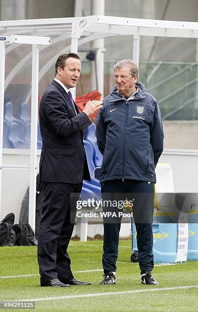 British Prime Minister David Cameron chats with England football manager Roy Hodgson during his visit to England's football training headquaters at...