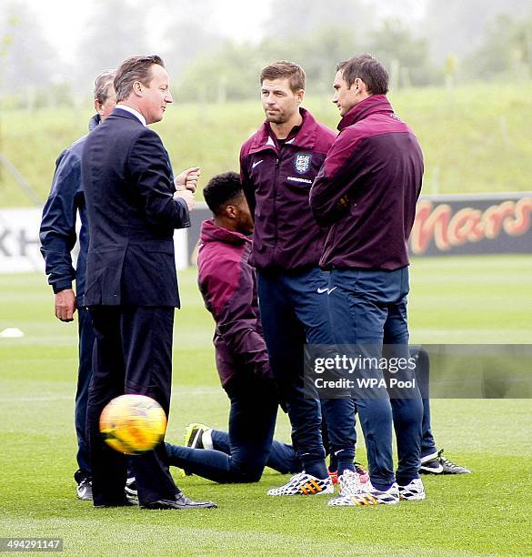 British Prime Minister David Cameron chats with England footballers Steven Gerrard and Frank Lampard during his visit to England's football training...