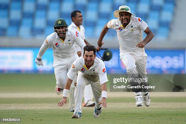 Yasir Shah of Pakistan celebrates with teammates Sarfraz Ahmed and Wahab Riaz after dismissing Adil Rashid of England to win the 2nd test match...