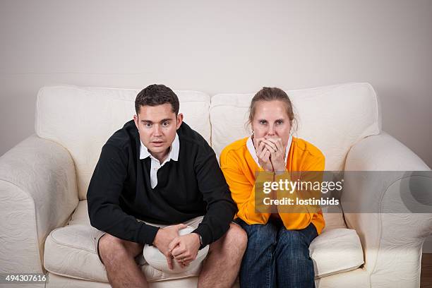 pair of rugby fans on rival team watching tense match - football australien stock pictures, royalty-free photos & images