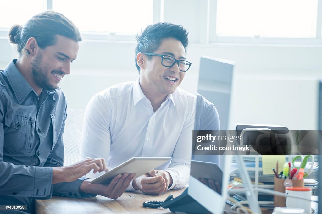 Two businessmen working with a digital tablet.