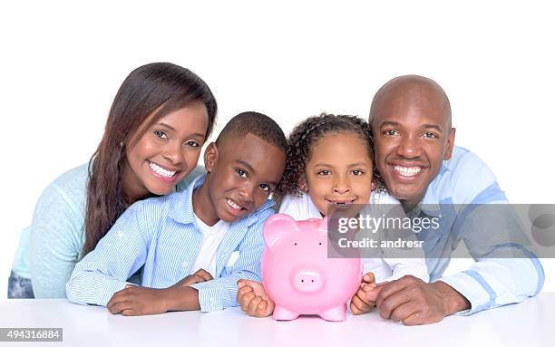family with their savings in a piggybank - couple saving piggy bank stock pictures, royalty-free photos & images