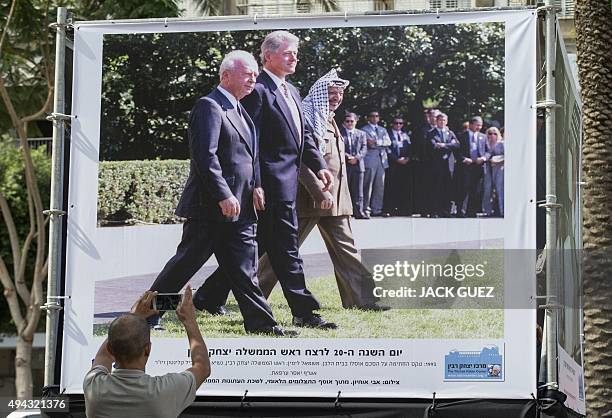 Man takes a picture of a photograph taken by Israeli Government Press Office Avi Ohayon showing late Israeli prime minister Yitzhak Rabin walking...