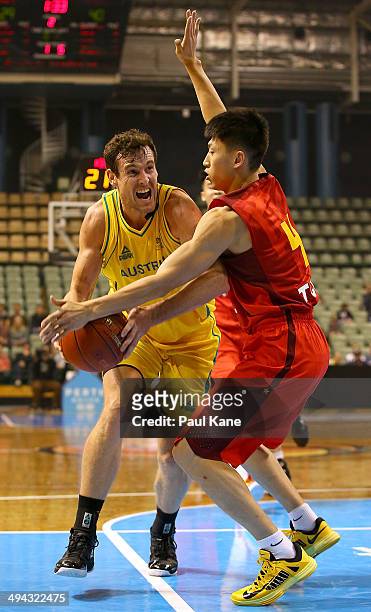 Ben Madgen of Australia drives to the basket against XiaoYu Liu of China during the 2014 Sino-Australia Challenge match between Australia and China...