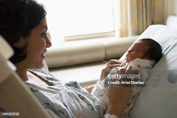 mother holding newborn baby in hospital - maternity ward stock pictures, royalty-free photos & images