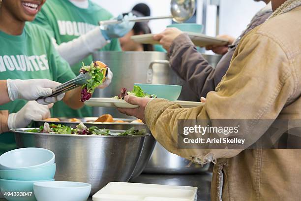 volunteers working in soup kitchen - charity and relief work foto e immagini stock