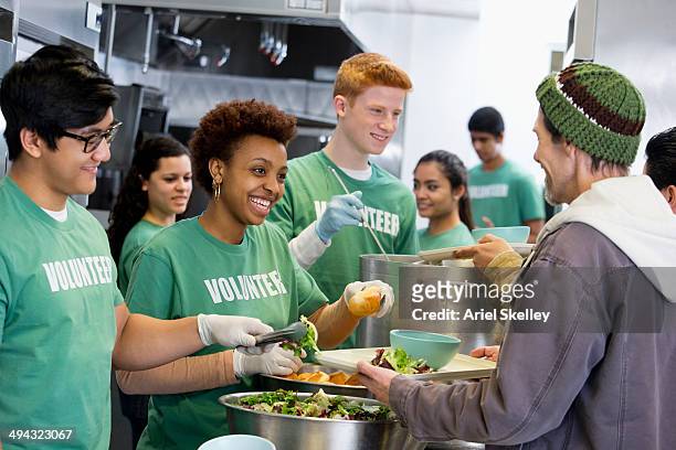 volunteers working in soup kitchen - charity and relief work stock pictures, royalty-free photos & images