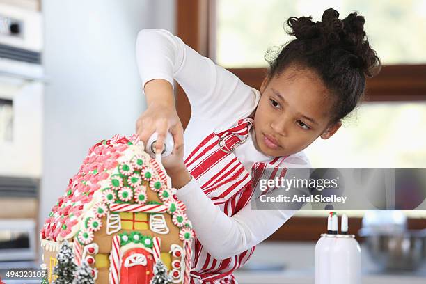 black girl decorating gingerbread house - gingerbread house stockfoto's en -beelden