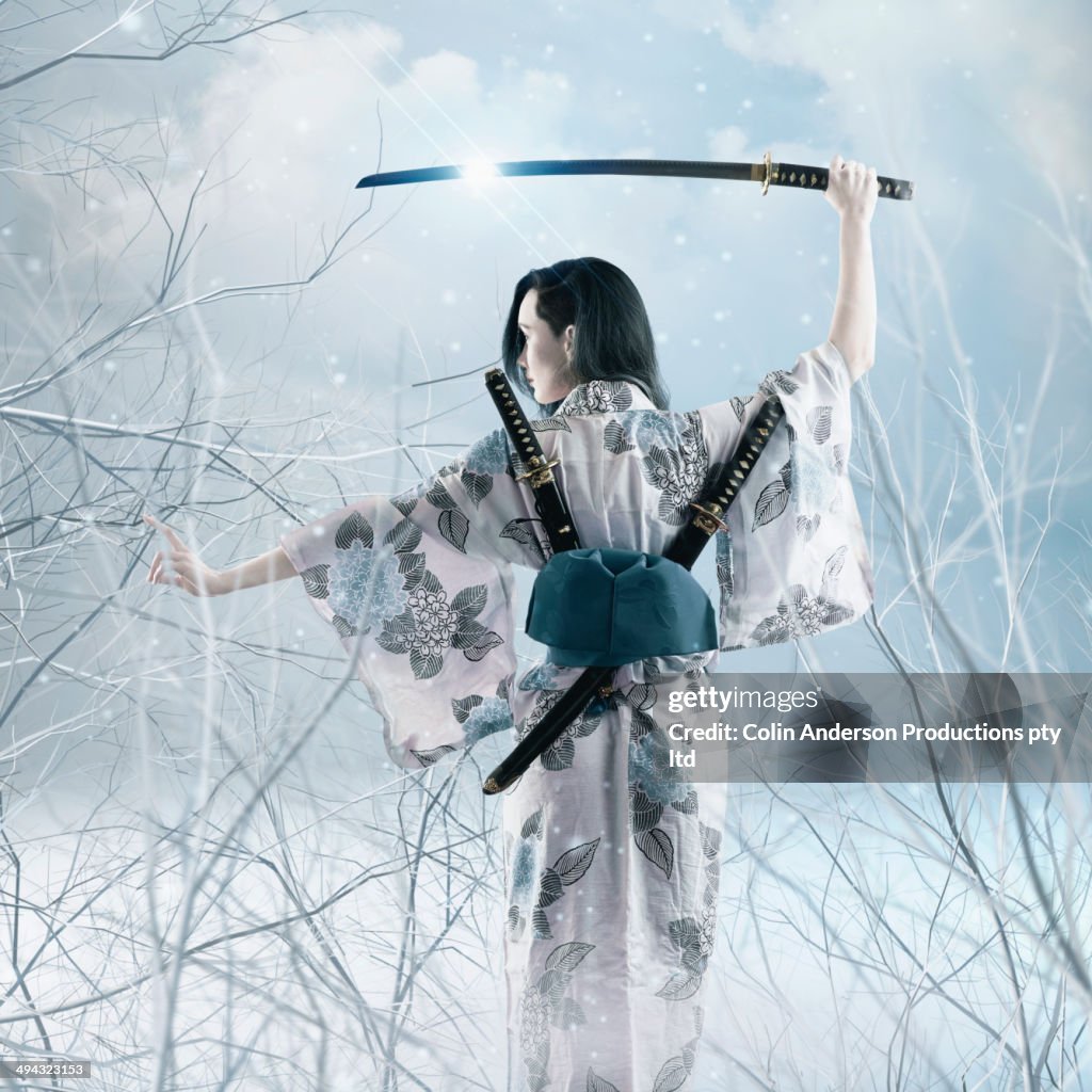 Mixed race woman wielding sword in kimono