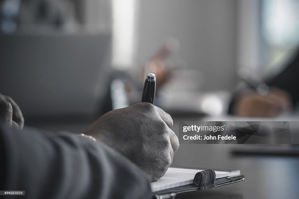 Businessman taking notes in meeting