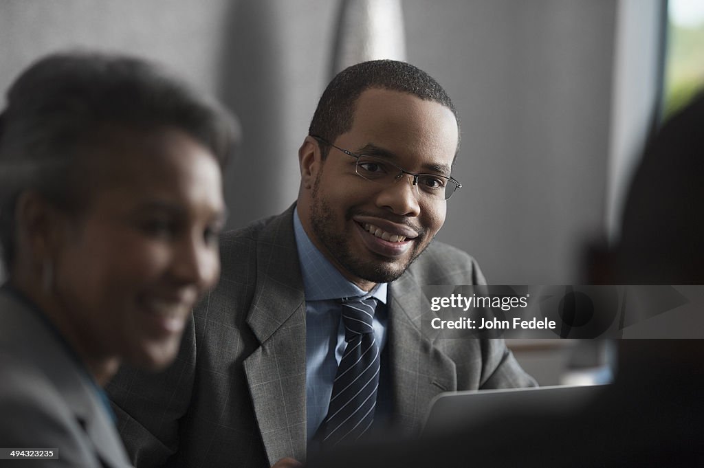 Businessman smiling talking in meeting