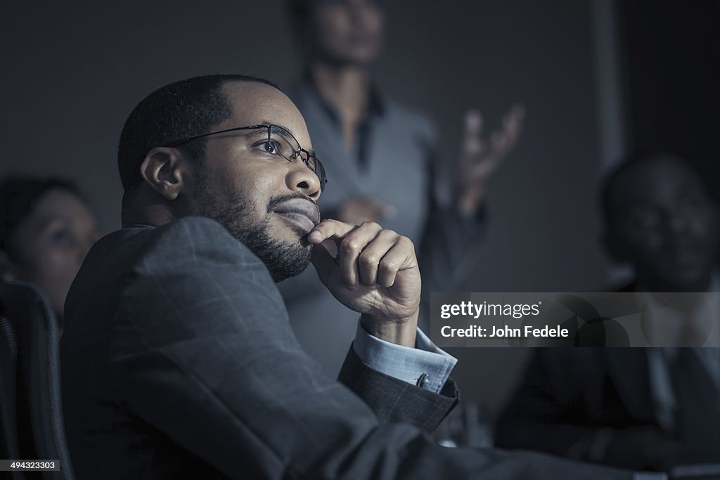 Business people watching projection in meeting