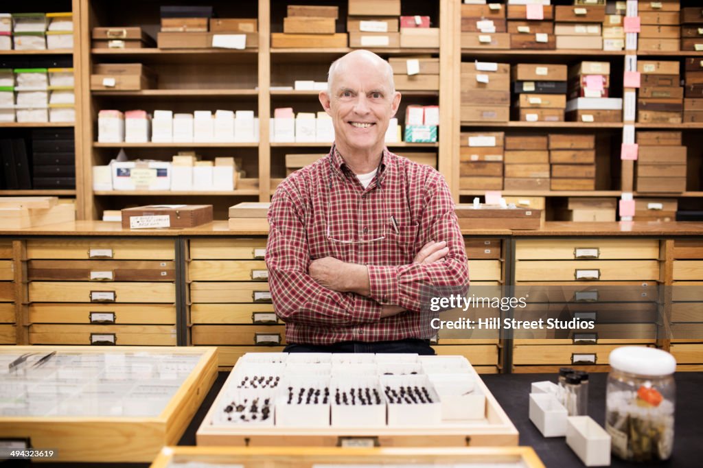 Caucasian curator with bug specimens in museum