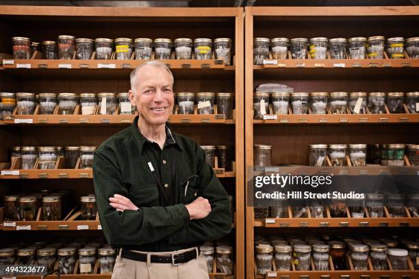 caucasian researcher smiling with specimens in museum - museumswärter stock-fotos und bilder