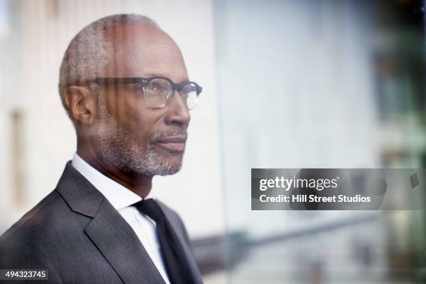 black businessman looking out window - soul searching stock pictures, royalty-free photos & images