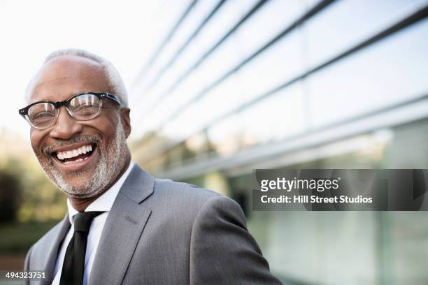 black businessman laughing outdoors - focus noir photos et images de collection