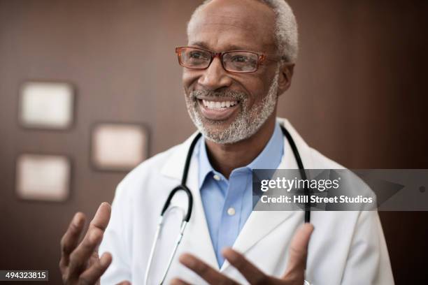 black doctor smiling in office - african american doctor stock pictures, royalty-free photos & images