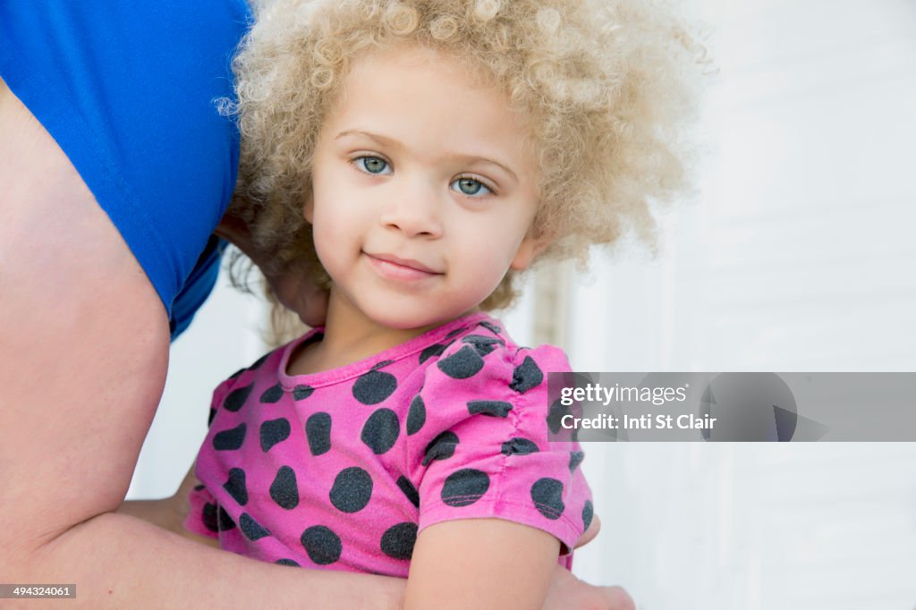 Mother picking up daughter outdoors