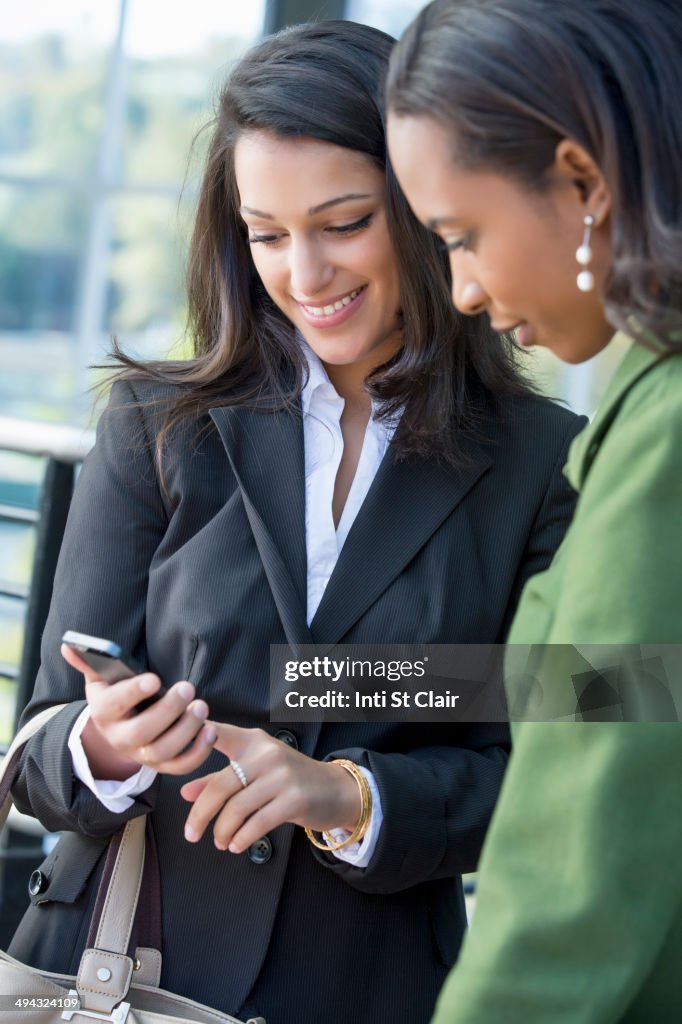 Businesswomen using cell phone outdoors