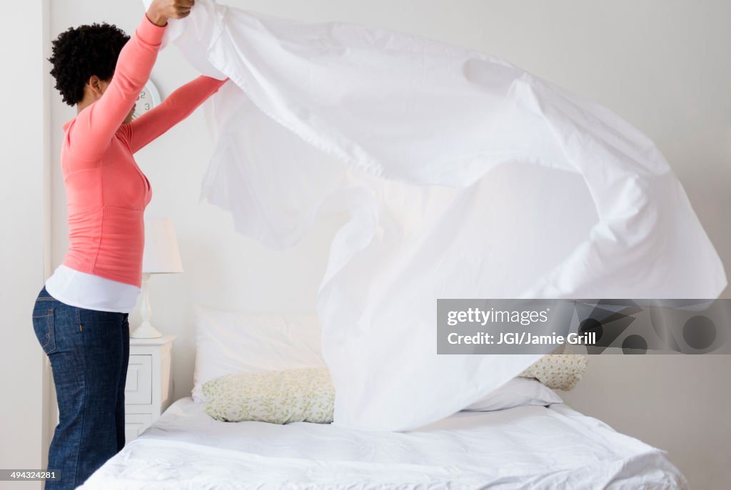 Black woman making bed