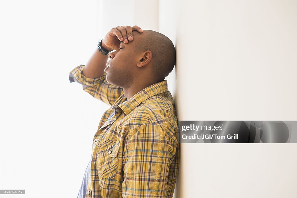 Black man rubbing his forehead