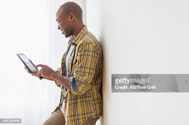 black man using digital tablet - shaved head profile stock pictures, royalty-free photos & images