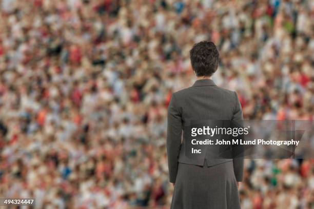 businesswoman standing before crowd - alone in a crowd sad stockfoto's en -beelden