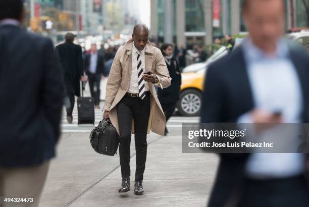 black businessman using cell phone on city street - new york personas fotografías e imágenes de stock