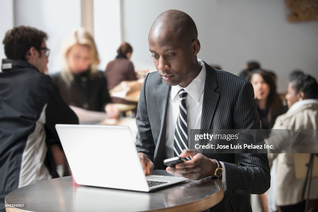 Black businessman working on laptop in cafe