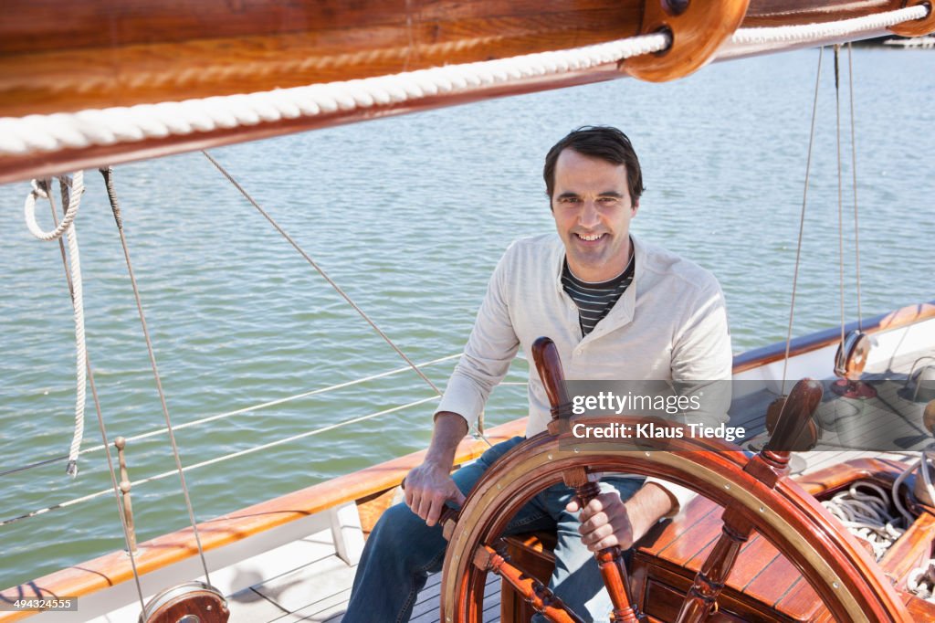 Caucasian man steering sailboat