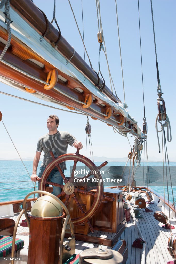 Caucasian man steering sailboat