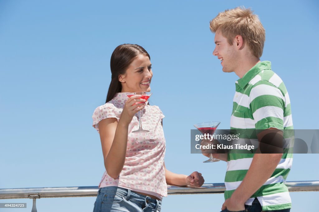 Caucasian couple enjoying cocktails outdoors
