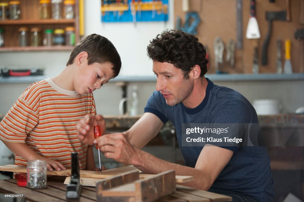 Caucasian father and son working in woodshop